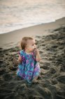Enfant jouant avec le sable sur la plage — Photo de stock