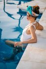 Young rich chinese woman relaxing in swimming pool at luxurious resort — Stock Photo