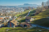 Живописный пейзаж маленького городка и дороги в долине зеленых гор, Швейцария — стоковое фото