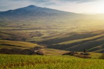 Paysage majestueux de vallée verdoyante avec champs et chaîne de montagnes en Toscane, Italie — Photo de stock