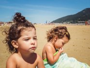 Портрет маленьких девочек, отдыхающих на пляже в солнечный день — стоковое фото