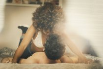 Giovane uomo e donna sensuale sdraiato sul letto e coccole in camera accogliente a casa — Foto stock