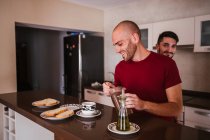 Glückliches homosexuelles Paar frühstückt gemeinsam in der Küche — Stockfoto