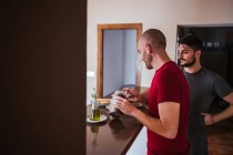 Happy gay couple having breakfast in kitchen together — Stock Photo