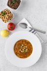 Traditional Harira soup for Ramadan in plate on white tabletop with ingredients — Stock Photo
