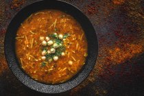 Traditionelle Harira-Suppe für Ramadan in schwarzer Schüssel auf dunkler Tischplatte — Stockfoto