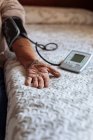 Homem mais velho verificando sua pressão arterial com máquina — Fotografia de Stock
