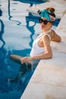 Young rich chinese woman relaxing swimming in a pool at a luxurious resort — Stock Photo
