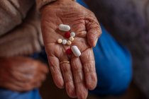 Detalhe de pílulas na mão de um homem velho — Fotografia de Stock