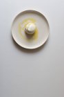 Bola de deliciosa burrata con aceite en placa de cerámica sobre fondo blanco - foto de stock