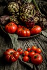 Набір різних свіжих овочів і серветки на сільському столі — стокове фото