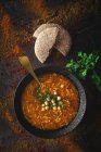 Traditionelle Harira-Suppe für Ramadan in Schüssel auf dunkler Oberfläche mit Brot und Koriander — Stockfoto