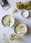 Миски смачного спаржевого вершкового супу з сиром і травами на білому фоні — стокове фото