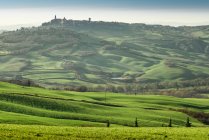 Picturesque landscape of green highlands with town in valley, Tuscany, Italy — Stock Photo