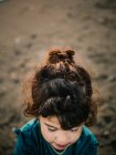Blick von oben auf ein kleines nachdenkliches Mädchen am Strand — Stockfoto