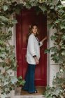 Stylish woman standing near red door — Stock Photo