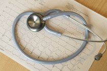 Stéthoscope médical et cardiogramme sur papier sur table — Photo de stock