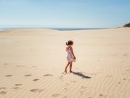 Süßes kleines Mädchen spielt mit Sand am Strand — Stockfoto