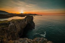Vista panoramica di enormi scogliere rocciose sopra l'acqua increspata contro il cielo del tramonto, Asturie, Spagna — Foto stock