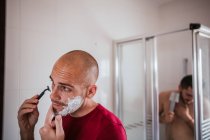 Gay couple shaving and having shower in bathroom together — Stock Photo