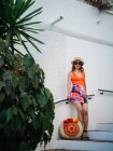 Mulher chinesa elegante nova no chapéu do panama e nos óculos de sol que se sentam nas escadas e que apreciam um dia brilhante do verão — Fotografia de Stock