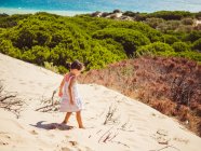 Маленькие девочки прогуливаются по пляжу в солнечный день — стоковое фото