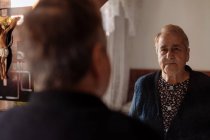 Älterer Mensch blickt in den Spiegel seines Hauses — Stockfoto
