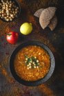 Traditionelle Harira-Suppe für Ramadan in schwarzer Schüssel auf dunklem Hintergrund mit Zutaten — Stockfoto