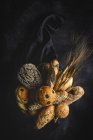 Ассортимент самодельных свежеиспеченных хлебов на черном фоне — стоковое фото