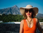 Giovane donna cinese di classe in panama cappello e occhiali da sole godendo di una brillante giornata estiva — Foto stock