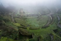 From above view of mossy green ruins in heavy fog, Italy — Stock Photo