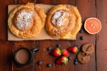 Frisches Heißgetränk und verschiedene leckere Frühstücksgerichte am Morgen auf einer Holztischplatte — Stockfoto