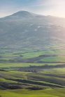 Величний ландшафт зеленої долини з полями та гірським діапазоном в Тоскані, Італія — стокове фото