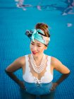 Giovane ricca donna cinese rilassante nuoto in piscina in un lussuoso resort — Foto stock