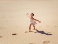 Carino bambina che gioca con la sabbia in spiaggia — Foto stock