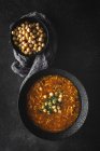 Traditional Harira soup for Ramadan and chickpeas on black tabletop — Stock Photo
