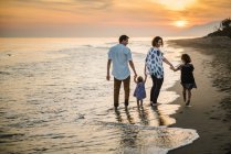 Family walking on beach — Stock Photo