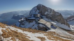 Landscape of ski resort station on rocky cliff in snowy mountains illuminated with sunlight, Switzerland — Stock Photo