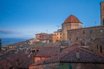 Внешний вид старых зданий из красного кирпича города Вольтерра против голубого неба, Италия — стоковое фото