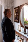 Älterer Mensch blickt in den Spiegel seines Hauses — Stockfoto