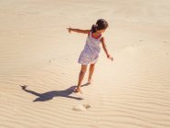Симпатична маленька дівчинка грає з піском на пляжі — стокове фото