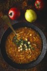 Traditional Harira soup for Ramadan in black bowl on dark surface with ingredients — Stock Photo