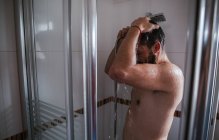 Hemdloser Mann mit Dusche im Badezimmer — Stockfoto