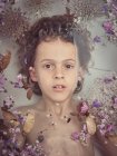 From above face of child in liquid between fresh petals of blooms — Stock Photo