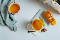 Mango-Kürbis-Smoothie in Gläsern auf weißem Hintergrund — Stockfoto