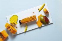 Mango und Kürbis Smoothie Flasche mit Zutaten auf weißem Hintergrund — Stockfoto