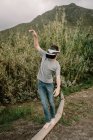 Giovane adolescente che gioca una simulazione di realtà virtuale con vr occhiali e bilanciamento su un tubo tubo — Foto stock