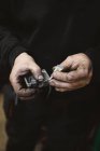 Unbekannter Reparateur mit schmutzigen Händen klebt kaputtes Teil in Werkstatt — Stockfoto