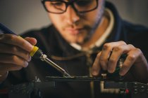 Erntehelfer repariert Mikrochip in Werkstatt — Stockfoto