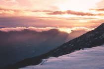 Pôr do sol sobre montanhas nevadas — Fotografia de Stock